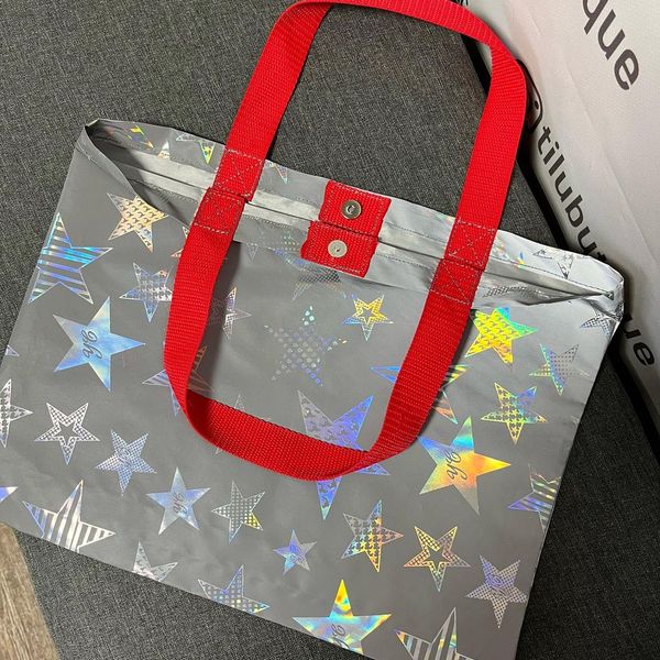 Reflective Svitashka Star shopping bag with short red handles on a magnetic button